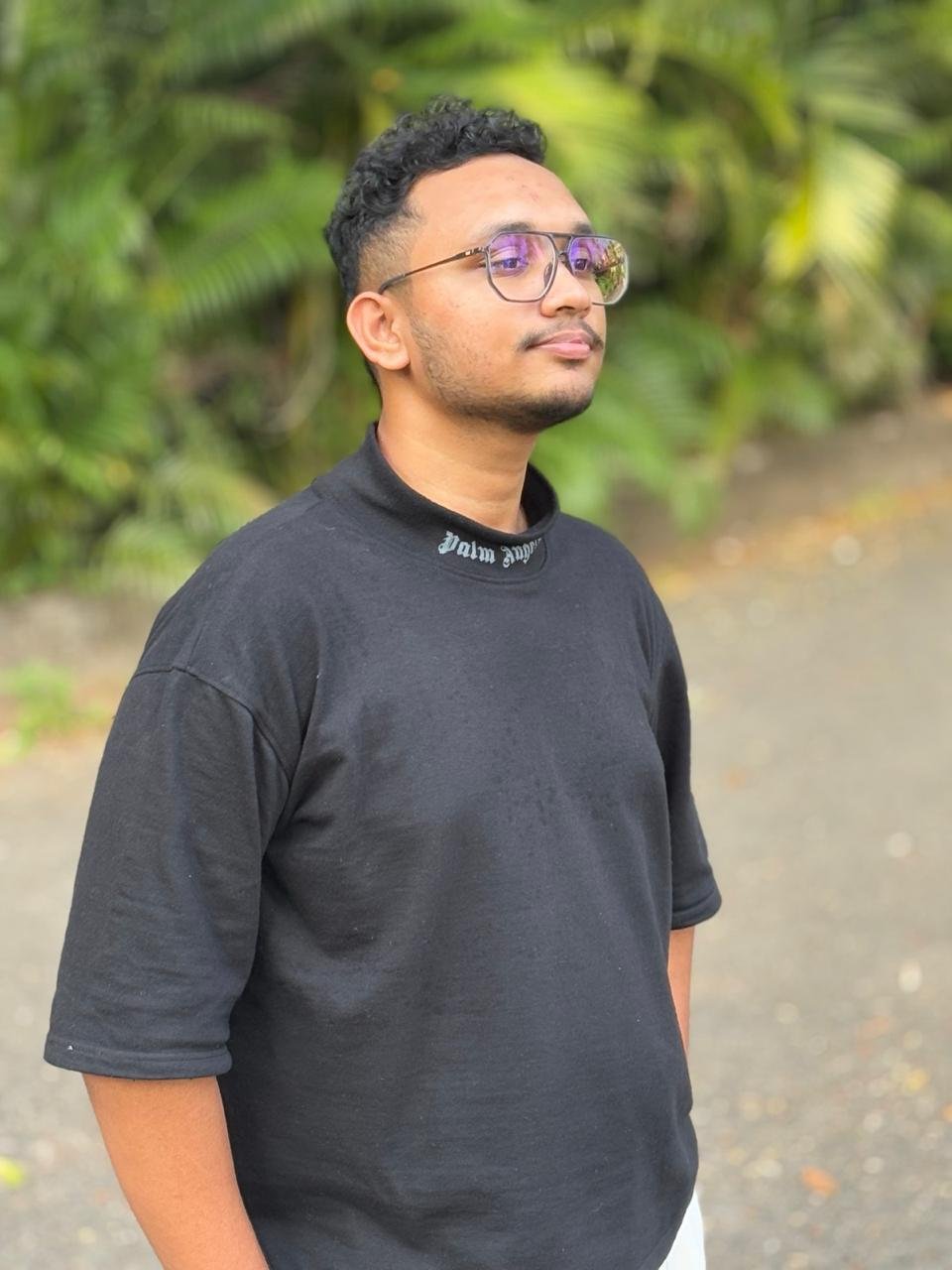 Ubaid Shamsudheen outdoors, wearing glasses and a black shirt